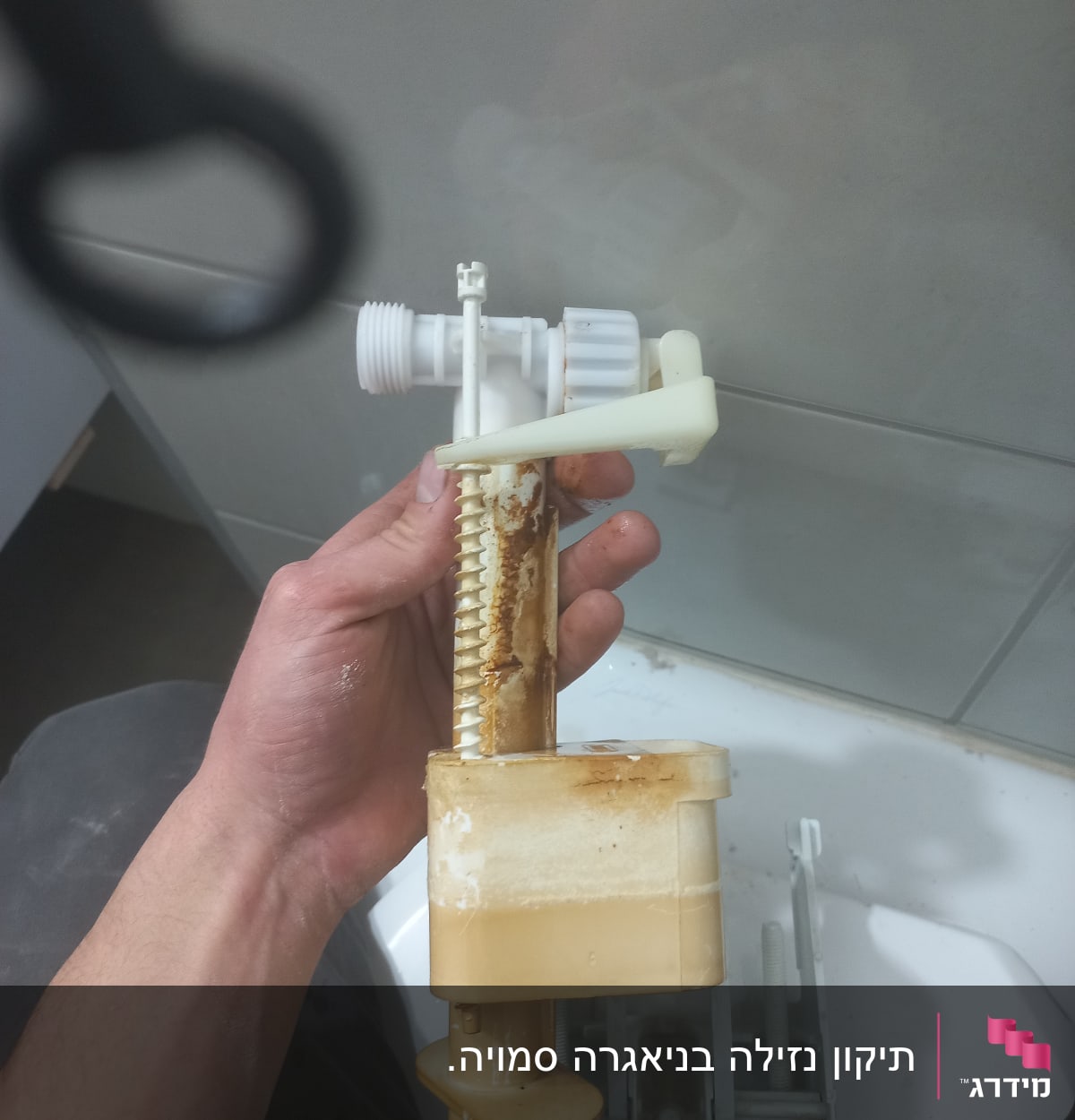 יד מחזיקה חלק פלסטיק של אסלה עם חלודה